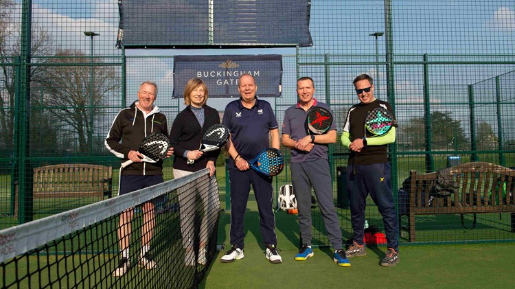 Five padel players on court at Sundridge park holding padel bats