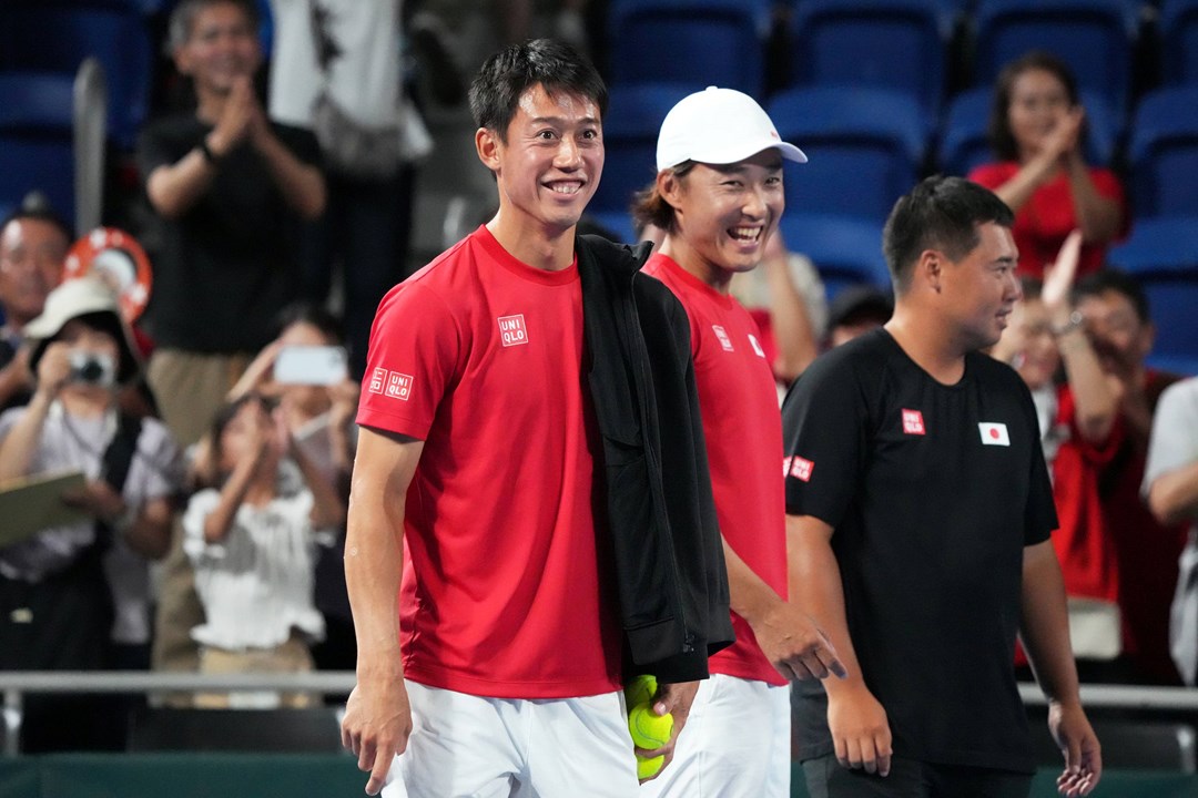 Kei Nishikori smiling on court at the Davis Cup