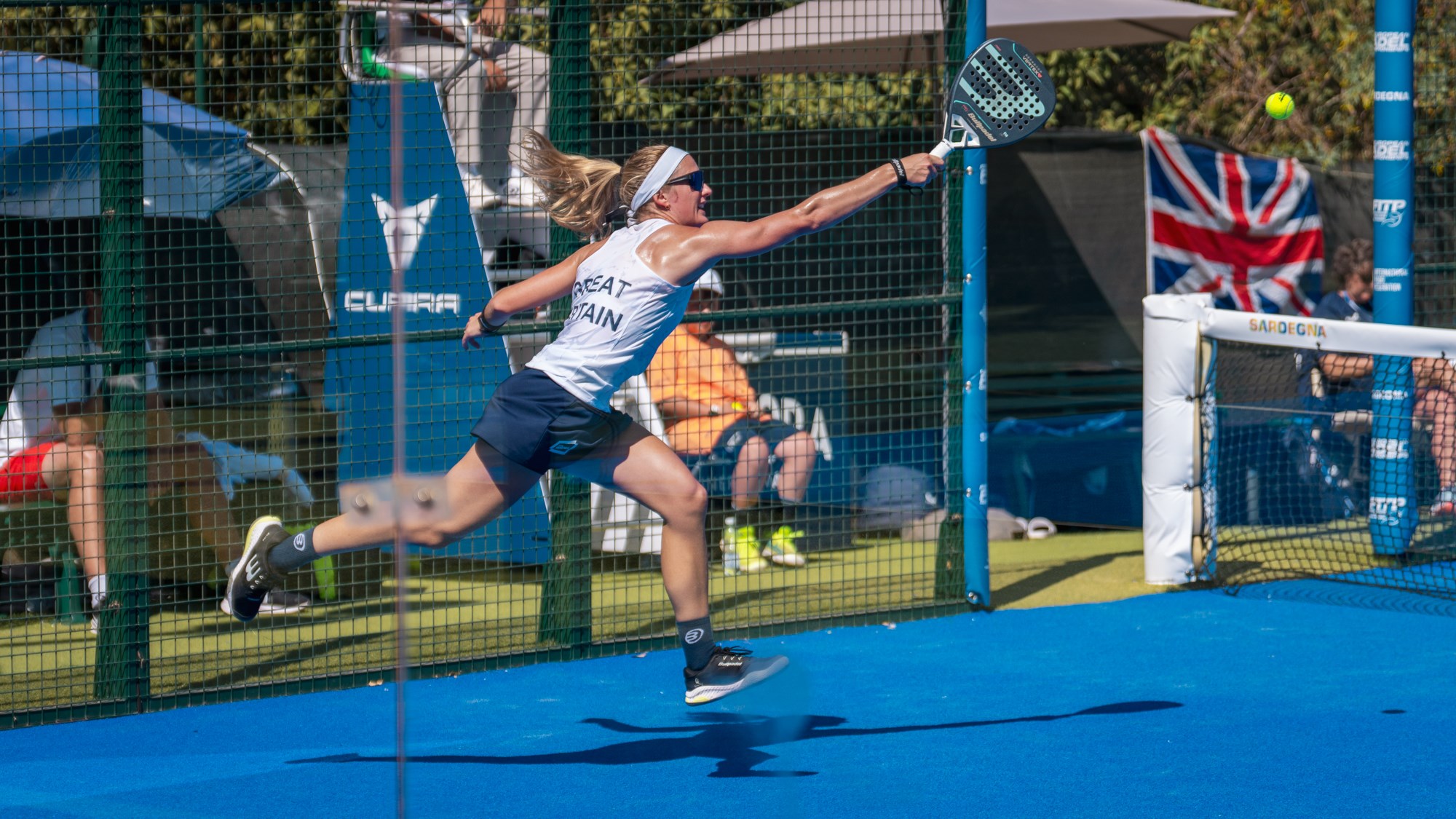 British padel player Victoria Nicholas reaching for a backhand on a padel court