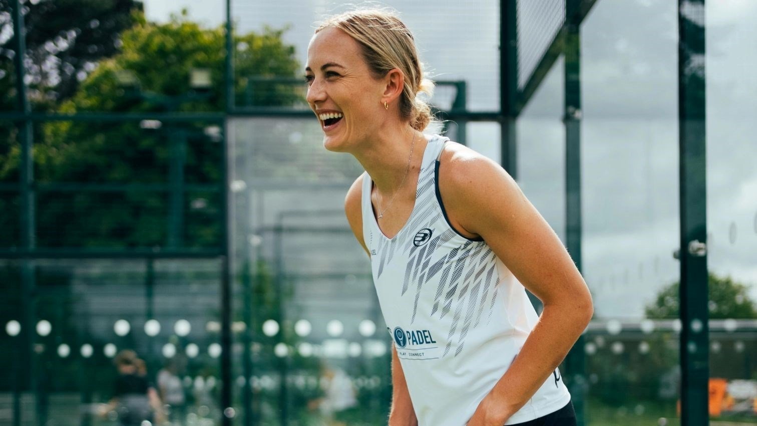 An image of British padel player Victoria Nicholas smiling while on a padel court