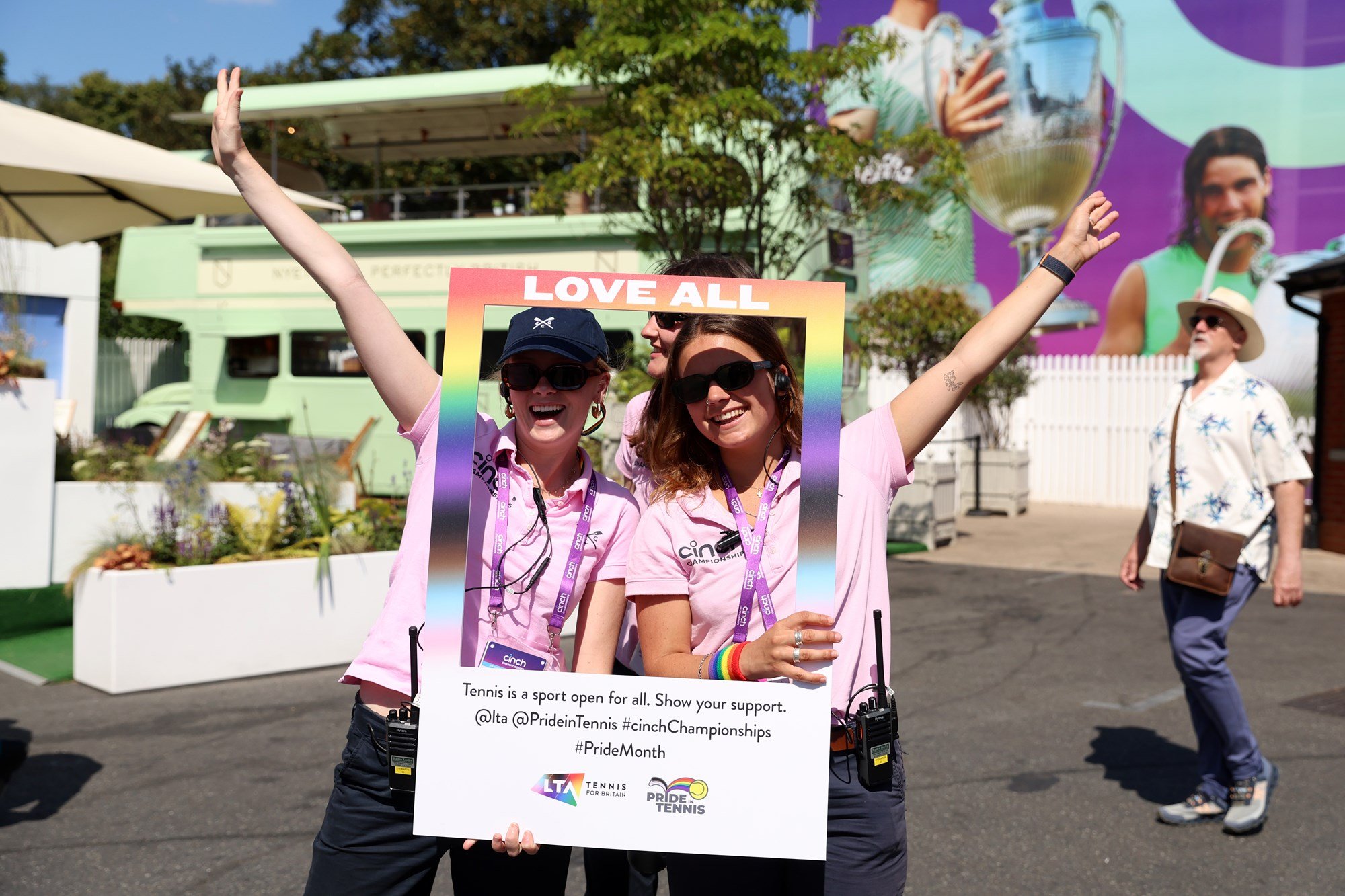 Two cinch Championships volunteer posing with a pride month picture frame