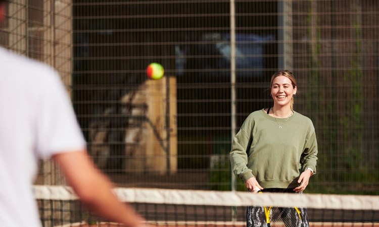 Female player laughing on court about to take a shot