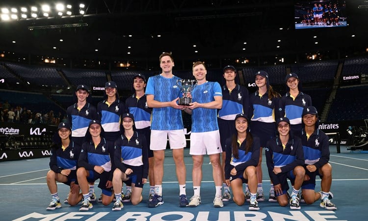 Hnery Patten and Harri Heliovaara holding the 2025 Australian Open men's doubles trophy