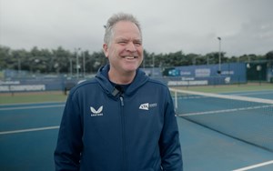 Tennis coach, Chris Wilkinson  smiling on court