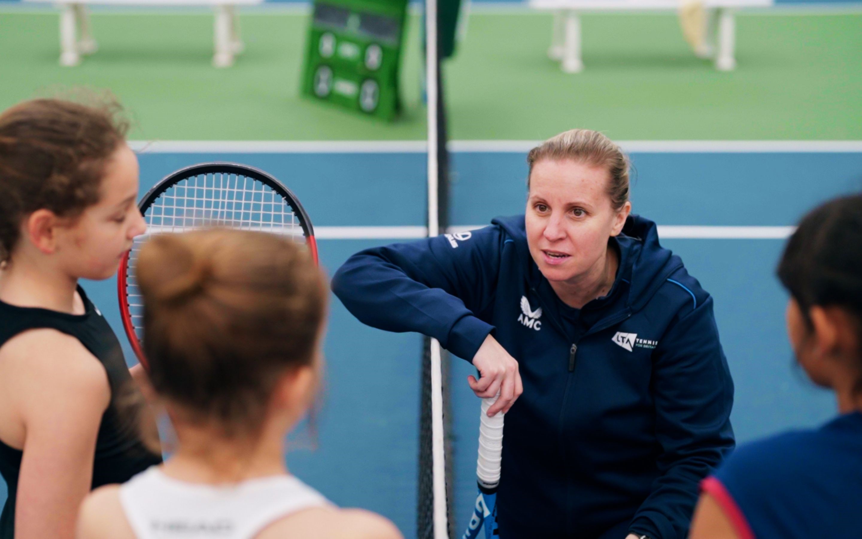 Coach Hollie Bainbridge chatting to young players by the net