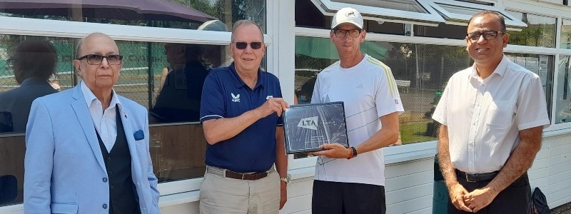 Group of men at Riverside Tennis Club with Mohammad Yasin and David Rawlinson holding the framed award