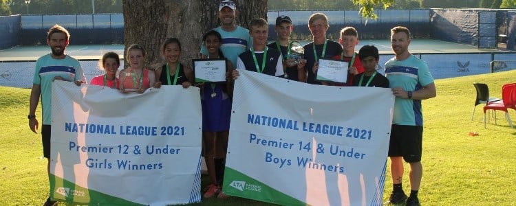 12U girls and 14U boys winning teams standing in a line holding the National League 2021 winners signs