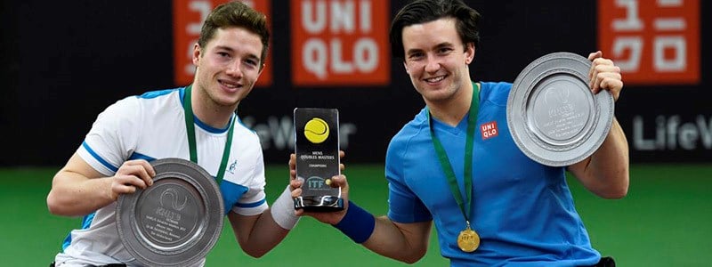 Gordon Reid and Alfie Hewett with medal around their neck holding the ITF trophy