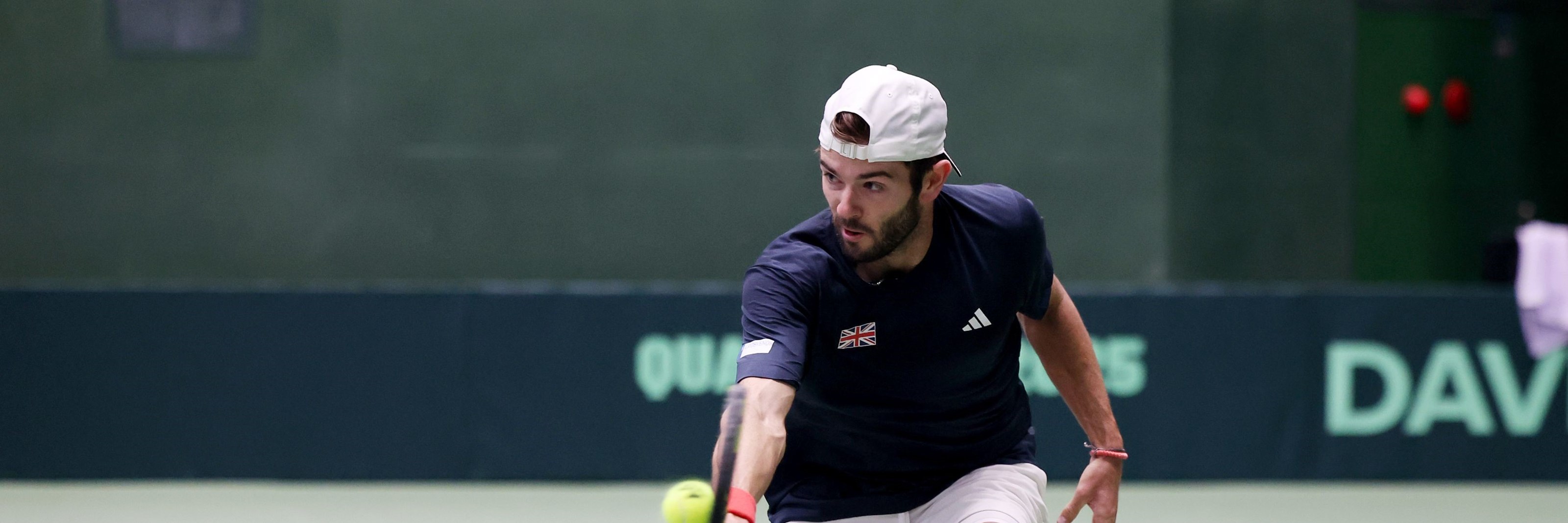 Jacob Fearnley reaching to hit a backhand on court at the Davis Cup Qualifiers against Japan