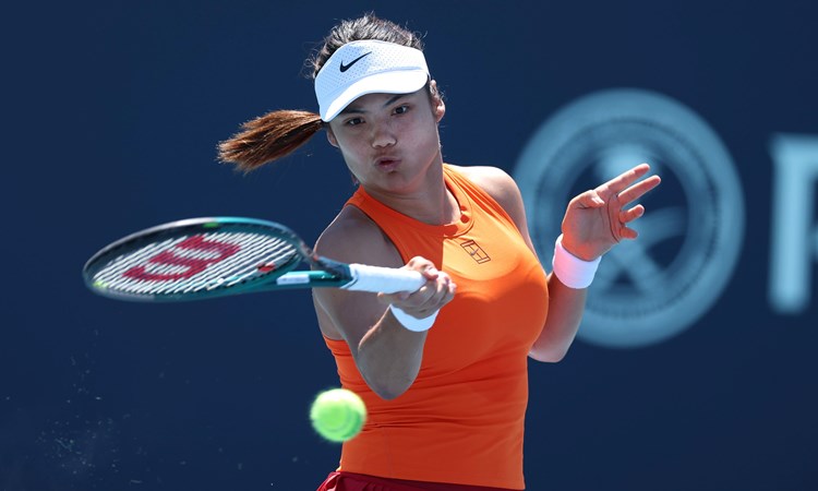 Emma Raducanu, wearing a Nike orange tennis top, hitting a forehand on court in the third round at the Miami Open