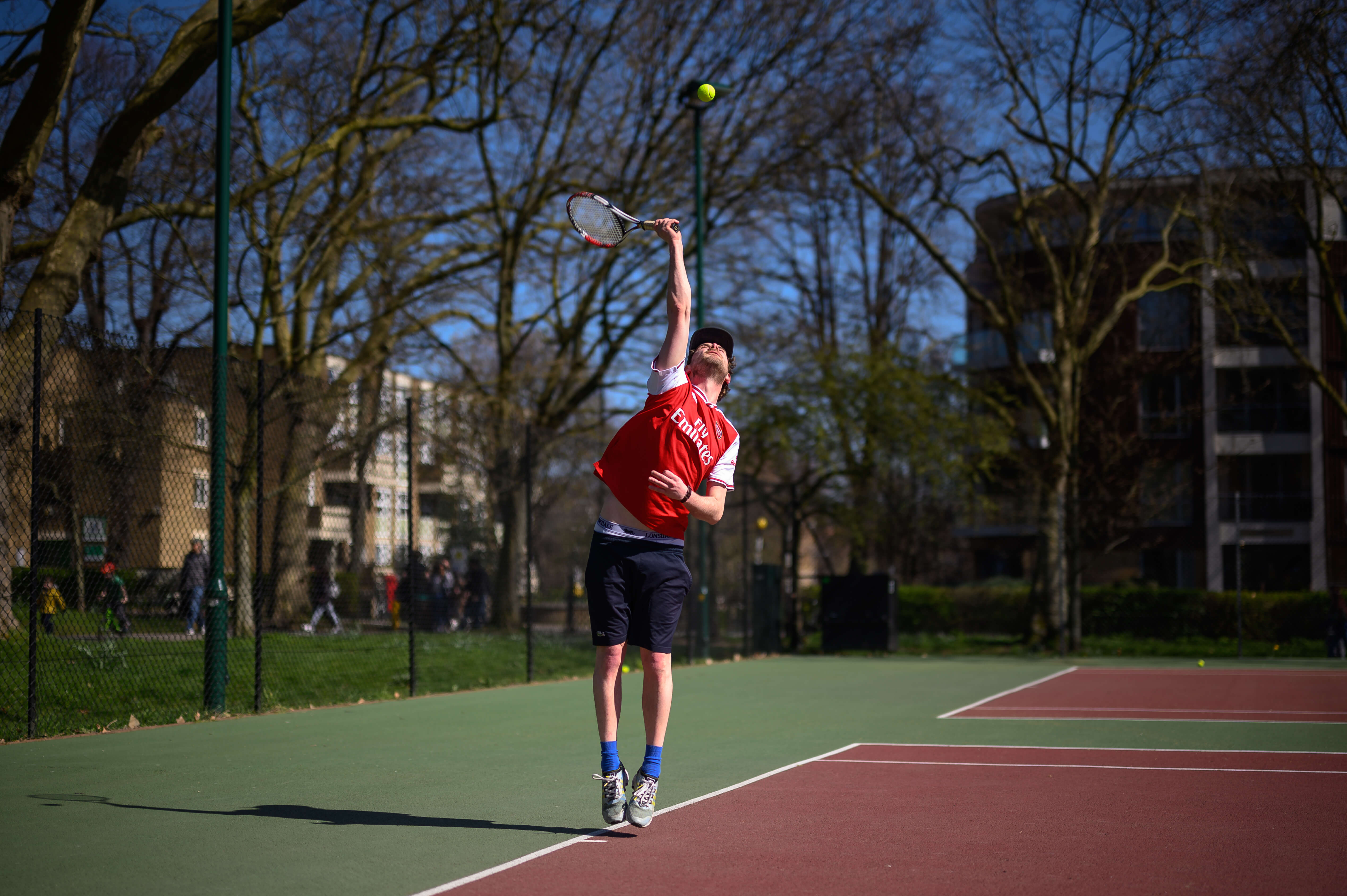 An amateur player hits a serve