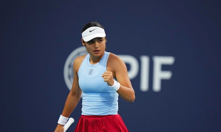 Emma Raducanu wearing a blue Nike top while clenching her fist on court at the Miami Open