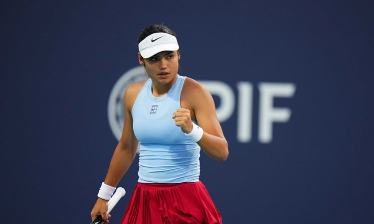 Emma Raducanu wearing a blue Nike top while clenching her fist on court at the Miami Open