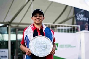 Gusic-Wan holding the trophy at the Junior National Championships with a Great Britain flag draped around him