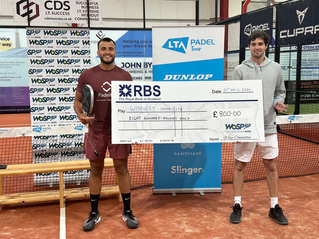 Louie Harris holding a giant cheque after winning the LTA British Tour Padel Stevenson title