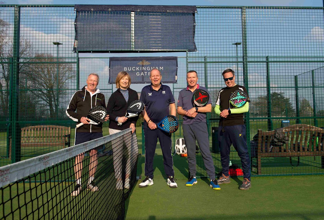 Five padel players on court at Sundridge park holding padel bats