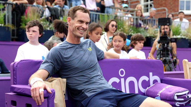 Andy  Murray sitting in a cinch branded chair on court at the cinch Championships while smiling