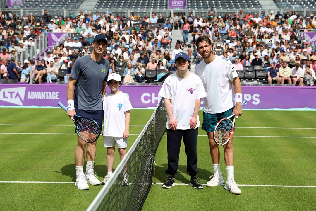 Andy Murray and Cam Norrie stood either side of a tennis net next to two children on court at the cinch Championships