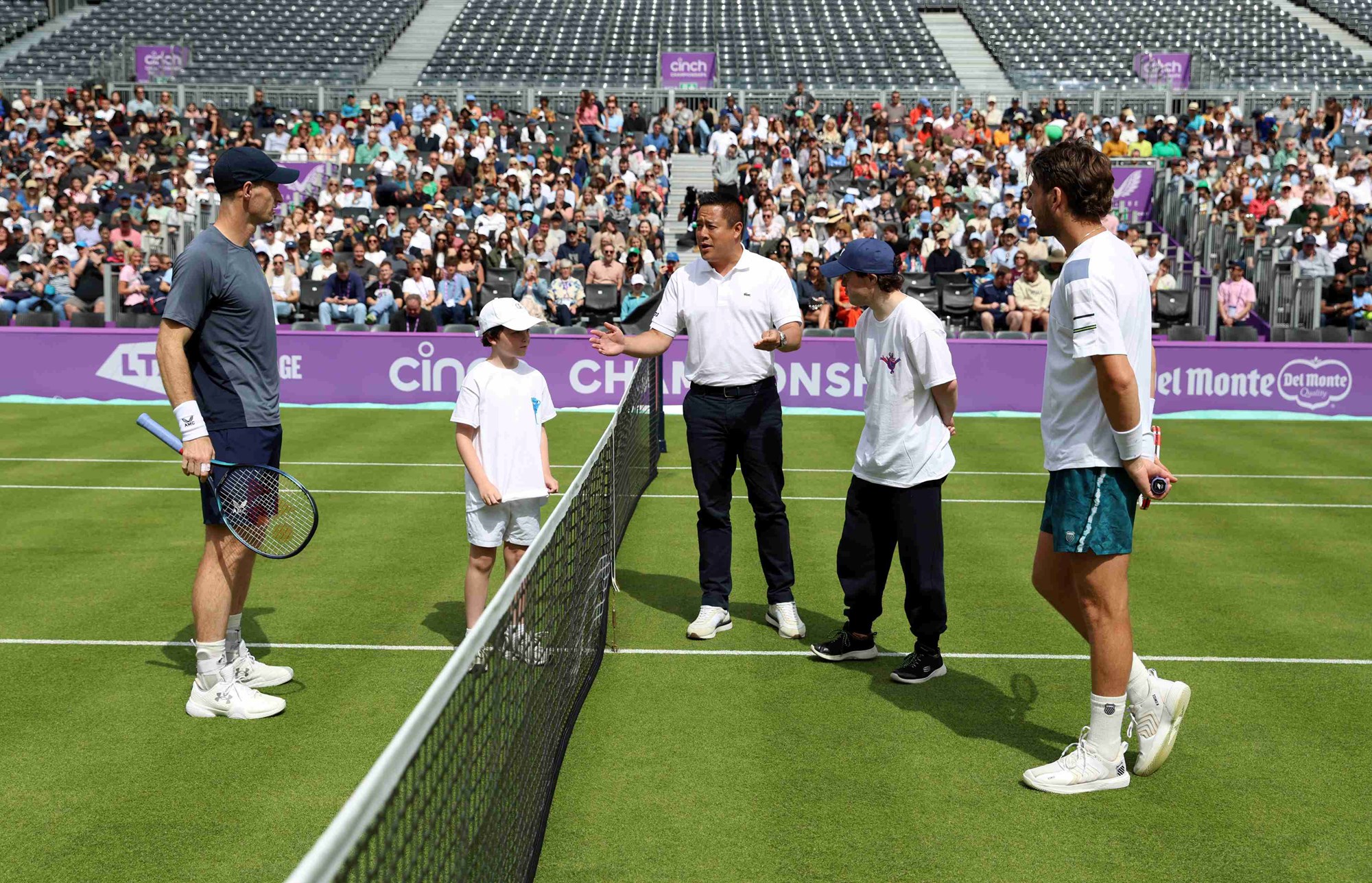 Andy Murray and Cam Norrie stood on court with two young children while chair umpire James Keothavong prepares for the coin toss