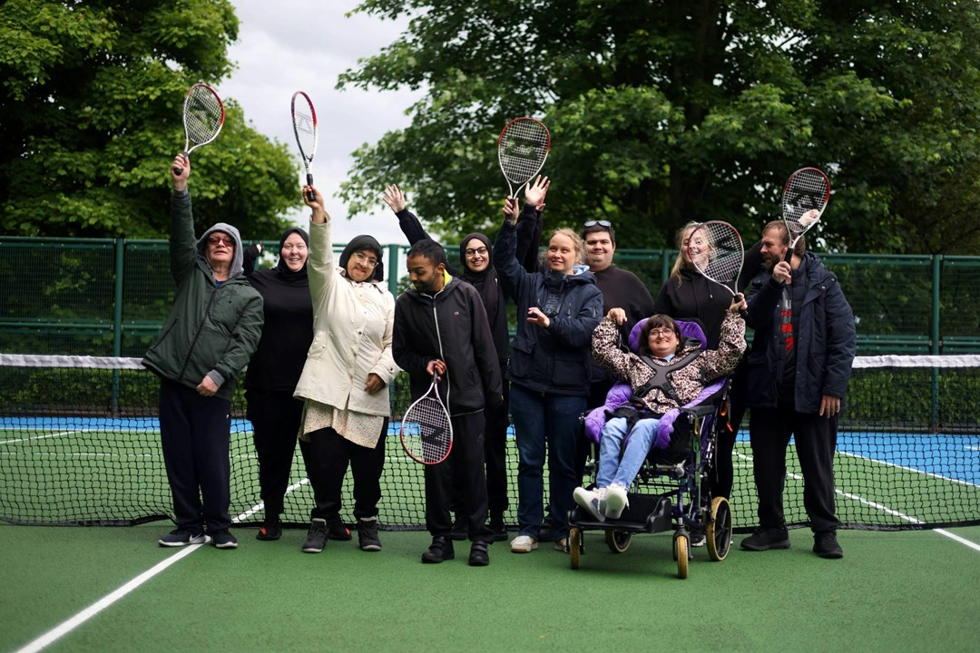 Players on court raising a racket at a disability tennis session and Lister Park courts