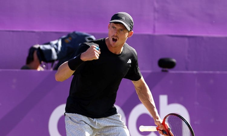 Billy Harris clenching his fist and cheering on court with cinch championships branding behind him