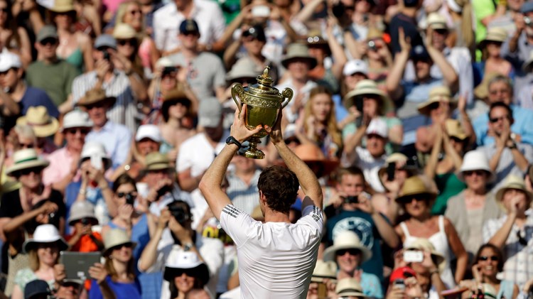 Andy Murray holds up the Wimbledon trophy to the crowd in 2013