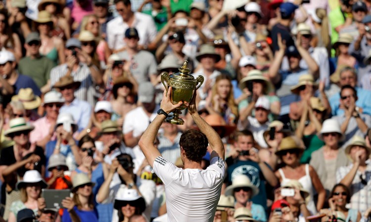 Andy Murray holds up the Wimbledon trophy to the crowd in 2013