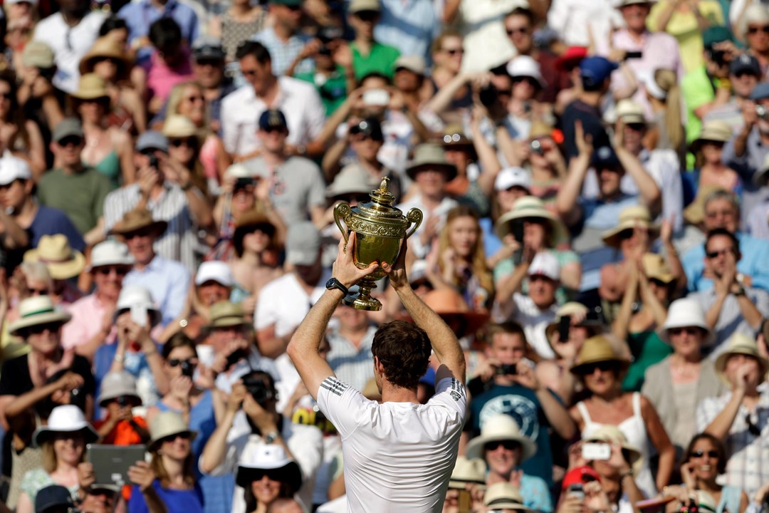 Andy Murray holds up the Wimbledon trophy to the crowd in 2013