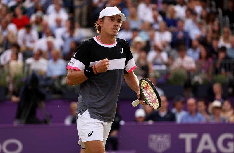 Alex De Minaur clenching his fist while holding a racket in his other in celebration on court at the cinch championships 