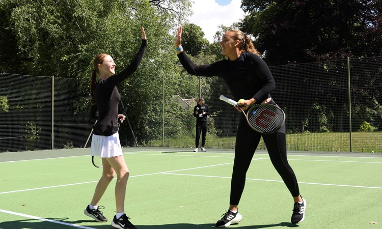 GB doubles player Freya Christie high fives a park tennis player