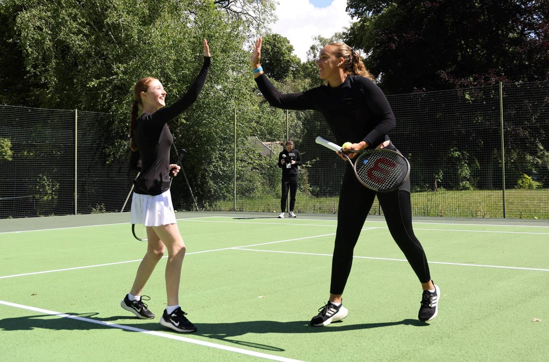 GB doubles player Freya Christie high fives a park tennis player