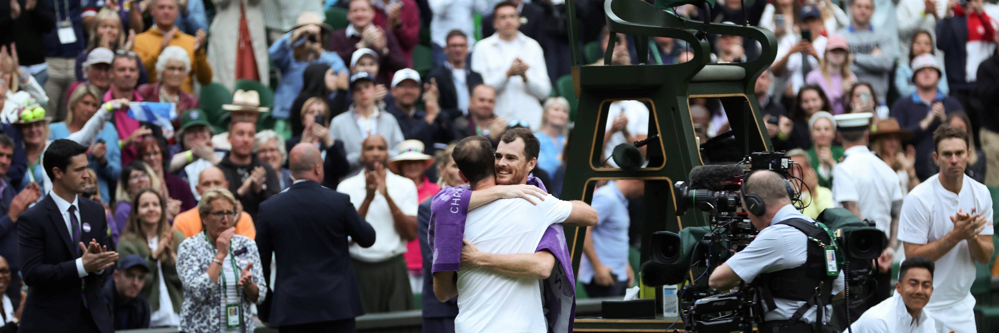 Andy Murray and Jamie Murray hug on court after their doubles match at Wimbledon
