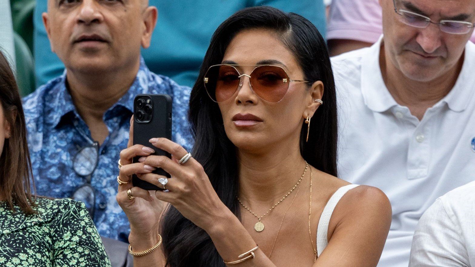 Nicole Scherzinger holding her phone up to take a picture on court at Wimbledon