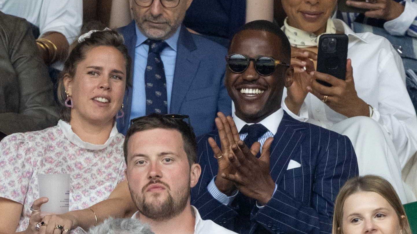 A picture of Doctor Who (Ncuti Gatwa) clapping while wearing a blue striped suit and sunglasses 