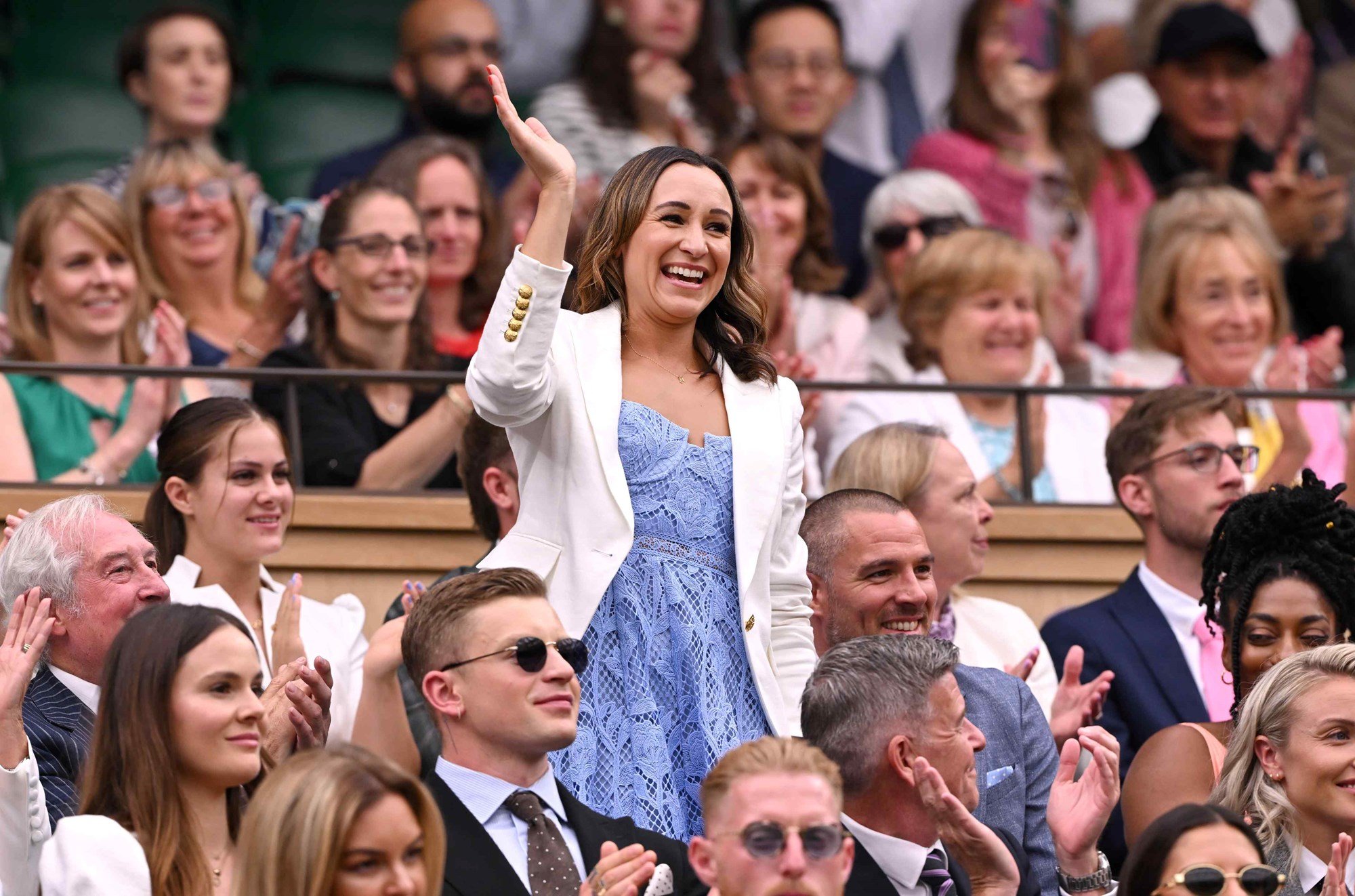 Jessica Ennis-Hill smiling and waving at the crowd while wearing a blue dress