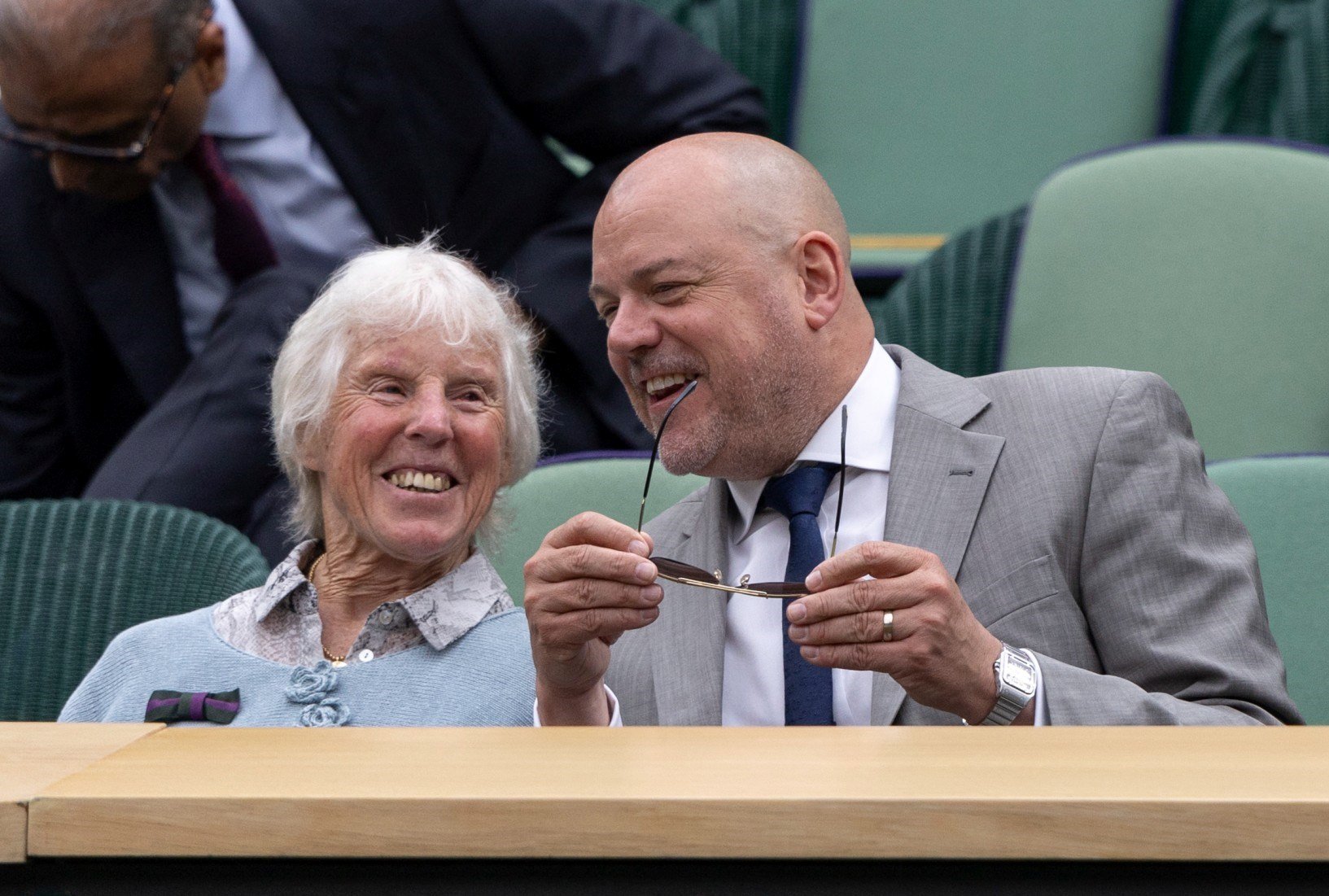 Anne Jones smiling and leaning into Mike Jones in the Royal Box at Wimbledon