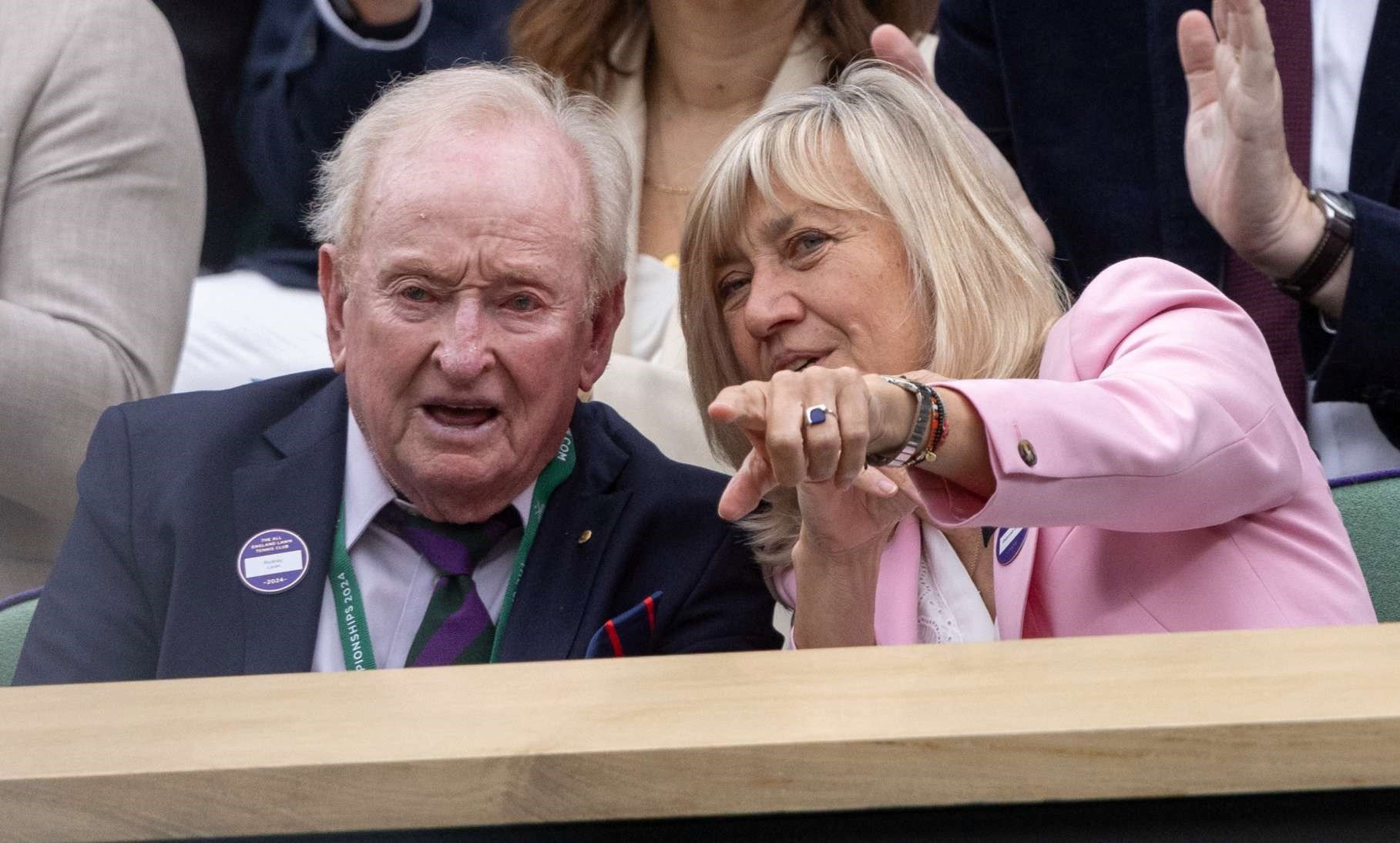 Rod Laver sat talking to a woman in the Royal Box at Wimbledon