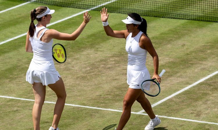 Mika Stojsavljevic and Mimi Xu high fiving on corut at Wimbledon