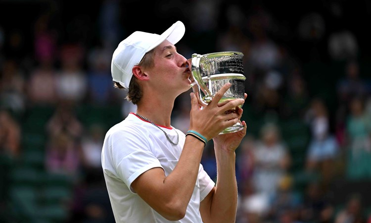 Henry Searle kissing his wimbledon juniors trophy