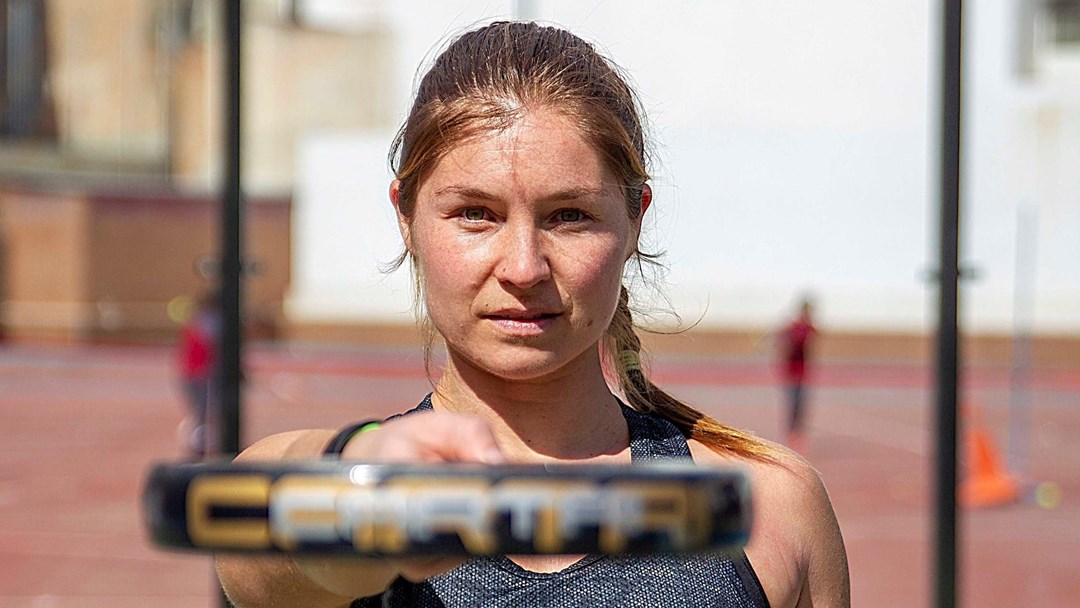 Hansie Ruddick pointing at the camera with her Padel racquet