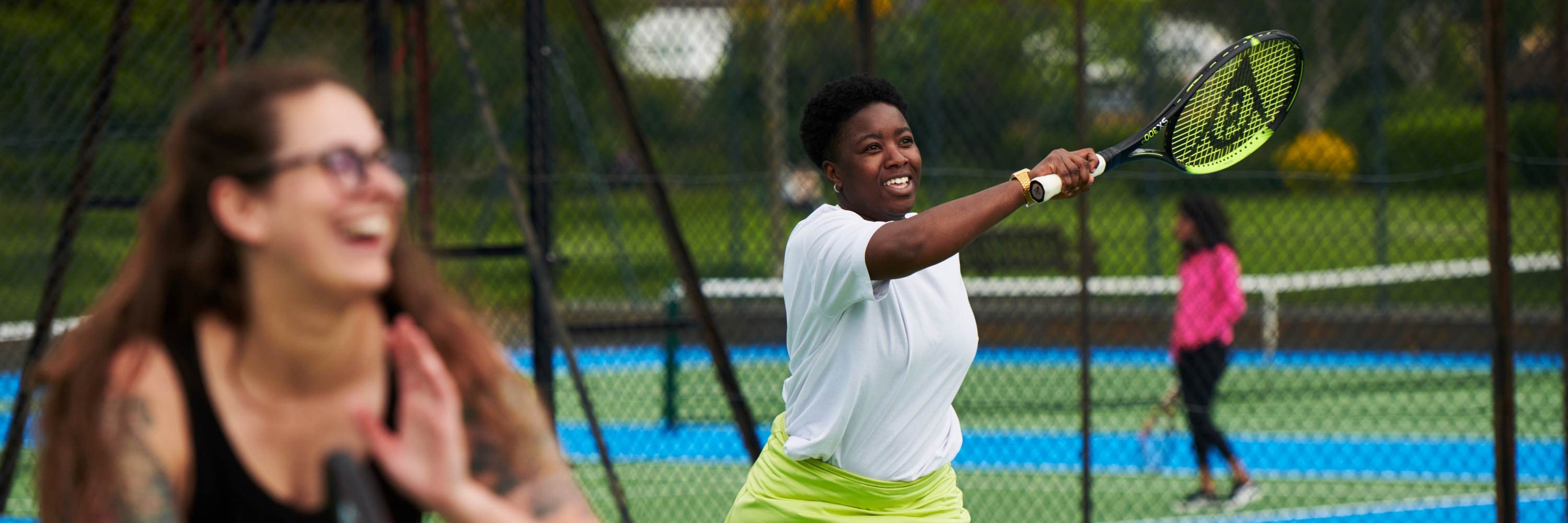 Woman hitting a forehand during a tennis session at a park court