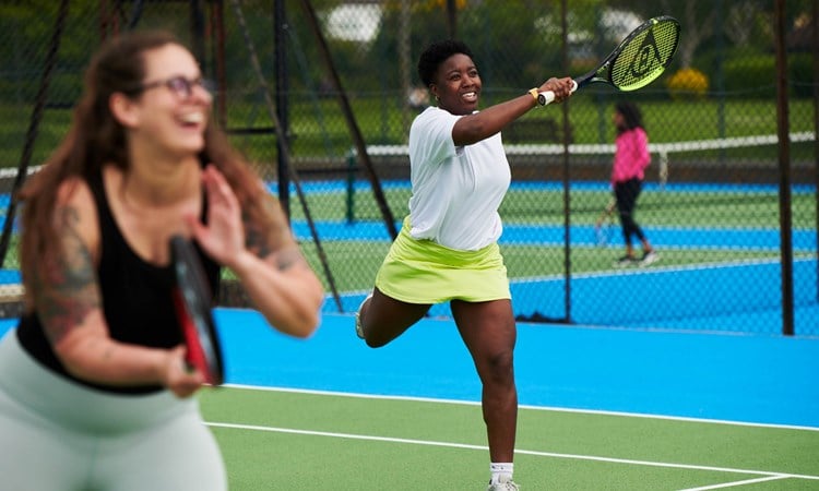 Woman hitting a forehand during a tennis session at a park court