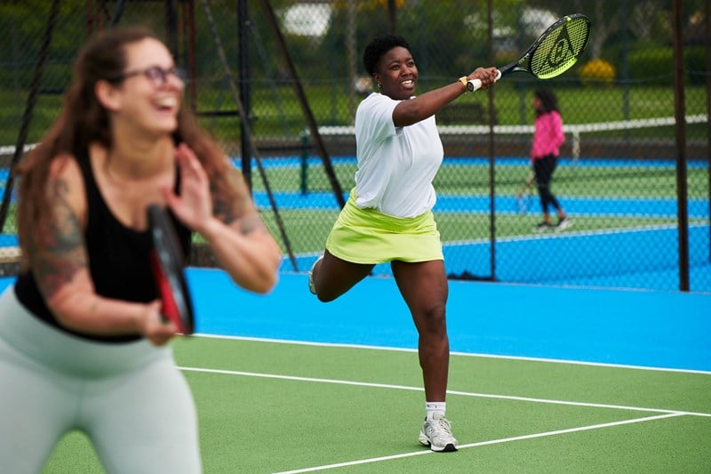 Woman hitting a forehand during a tennis session at a park court