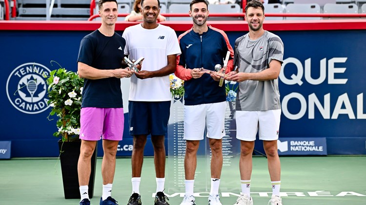 Joe Salisbury and Rajeev Ram holding the National Bank Open runners-up trophies next to champions Marcel Granollers and Horacio Zeballos