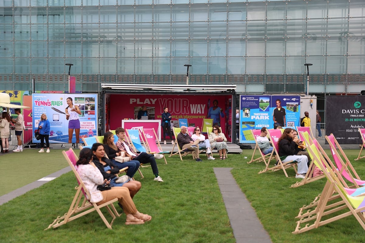 Fans lounging on deck chair, watching the big screen at the Davis Cup fan village