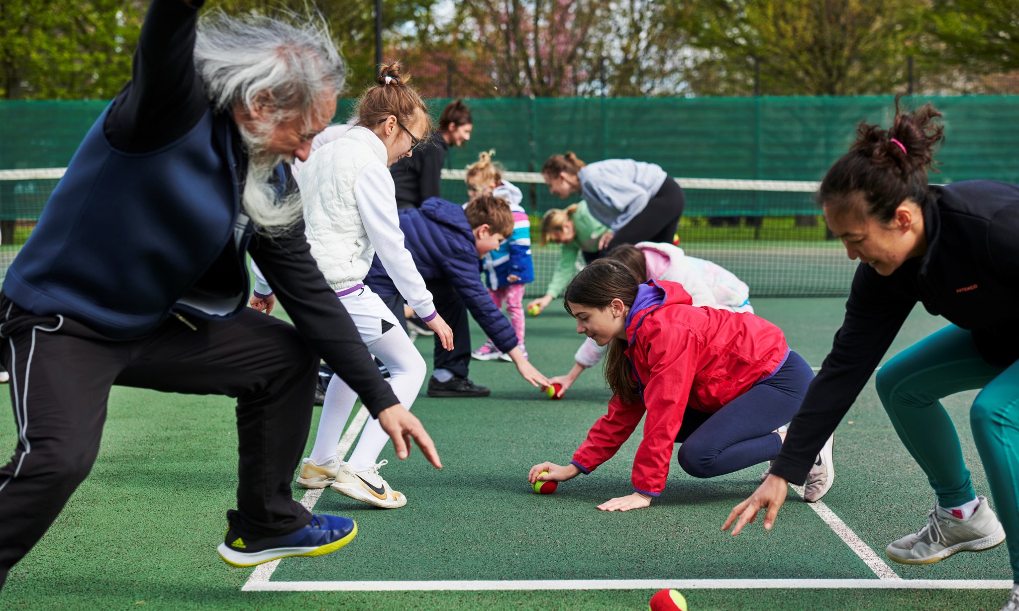 A group of adults and children taking part in an activity at a Barclays Free Park Tennis session