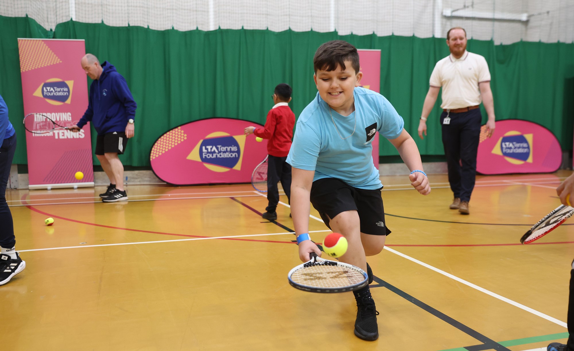 Child bouncing a ball on his racket at a Tennis Foundation ran tennis session