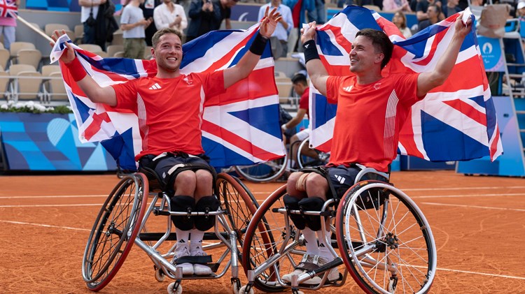 Alfie Hewett and Gordon Reid holding up GB flags behind their head at the Paralympics final