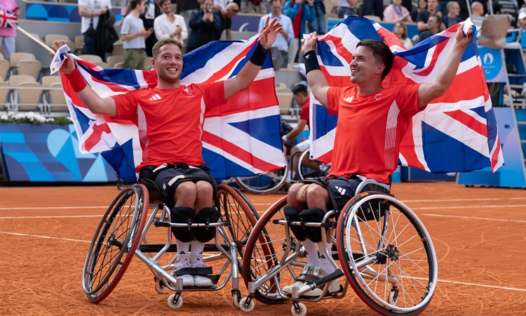 Alfie Hewett and Gordon Reid holding up GB flags behind their head at the Paralympics final