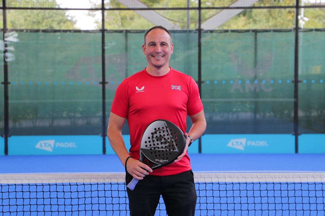 Steve Yeardley posing with a bat on a padel court